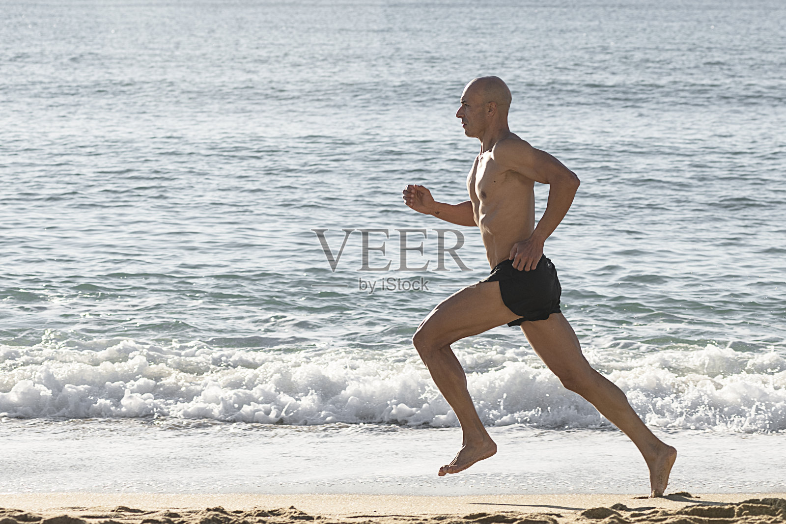 在海滩上跑步的男人照片摄影图片