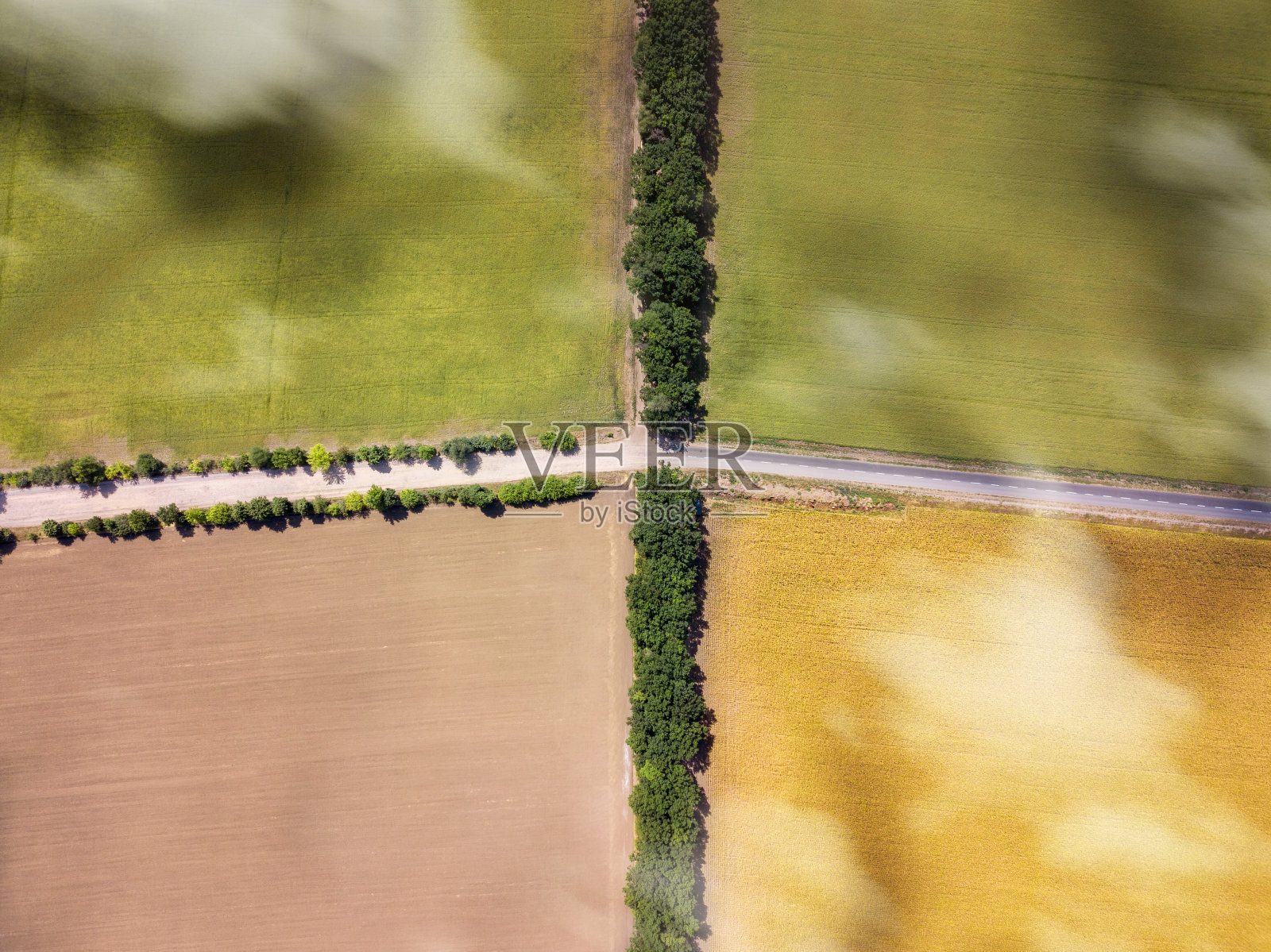 无人机俯瞰交叉道路上的农田。照片摄影图片