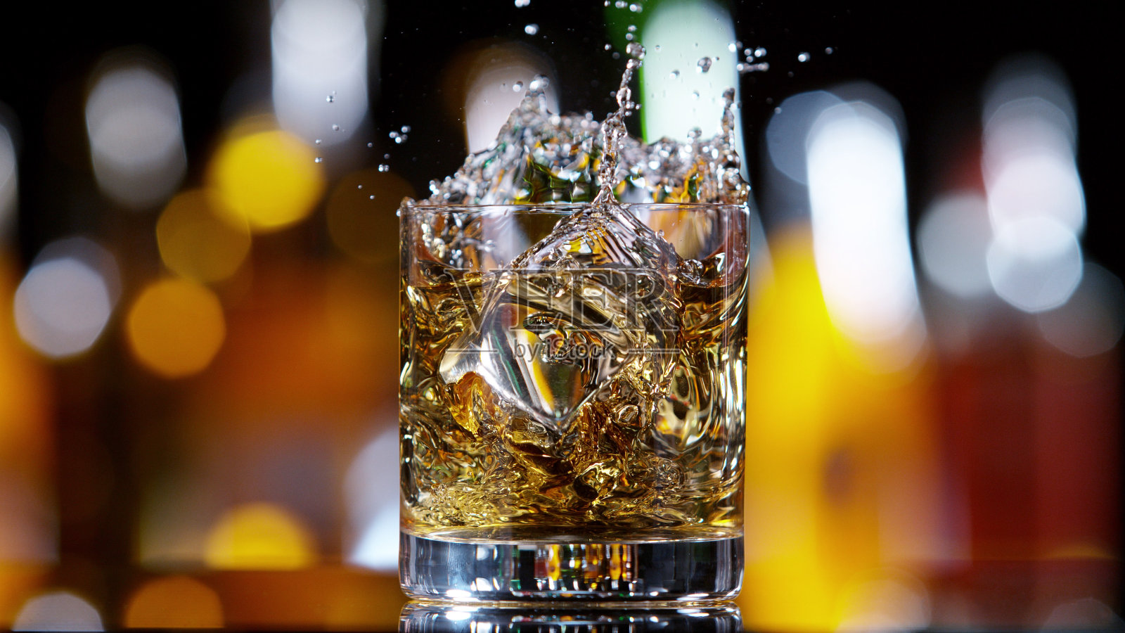 一杯威士忌与溅起的液体，酒吧的背景照片摄影图片