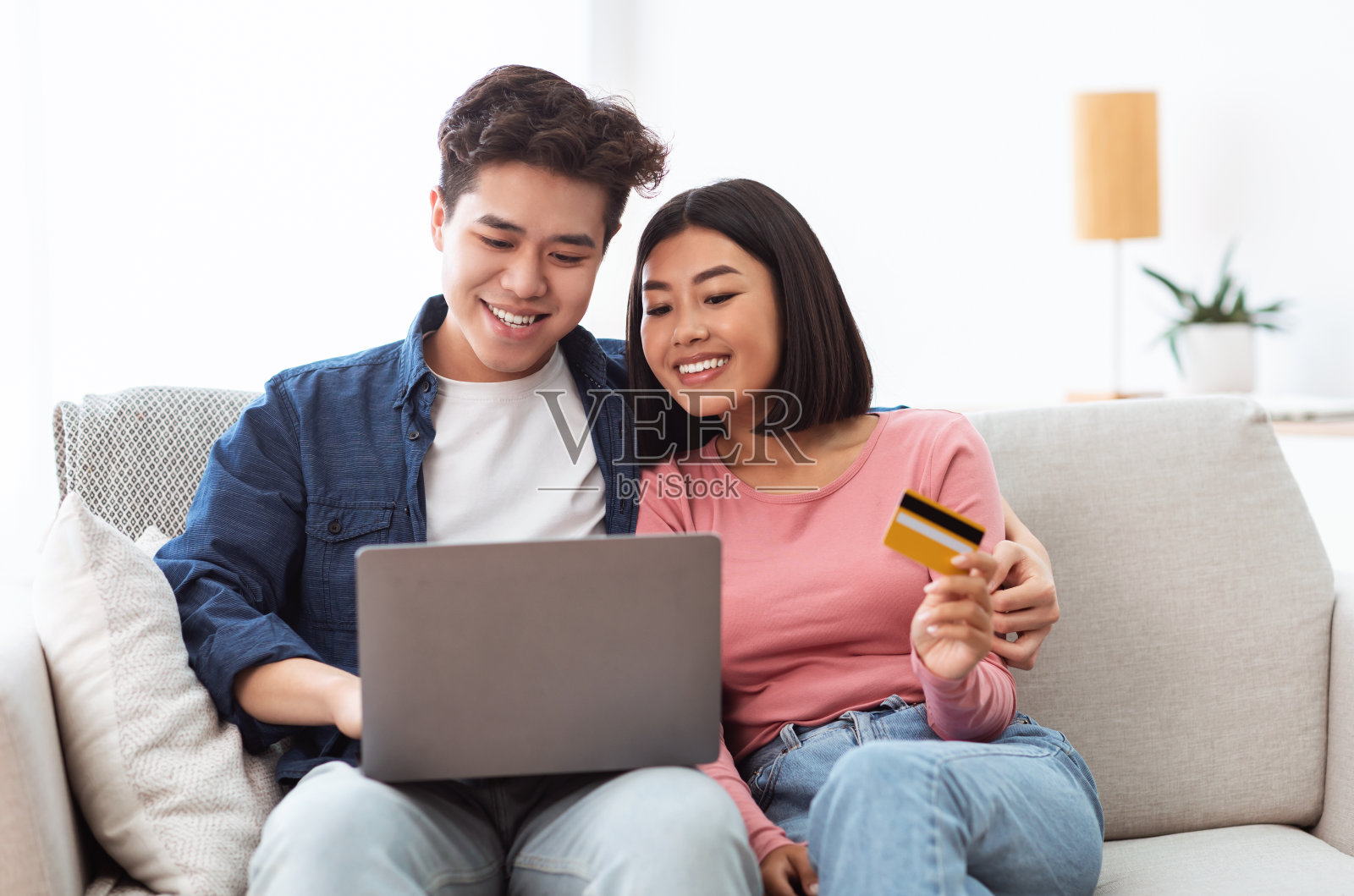 日本夫妇用笔记本电脑和信用卡在室内网上购物照片摄影图片