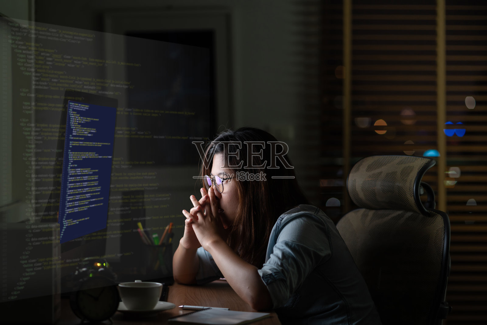 亚洲女商人努力工作与电脑桌面与编程源代码和运动图形在电脑屏幕上在工作地点晚些时候与兴奋和严肃的行动照片摄影图片