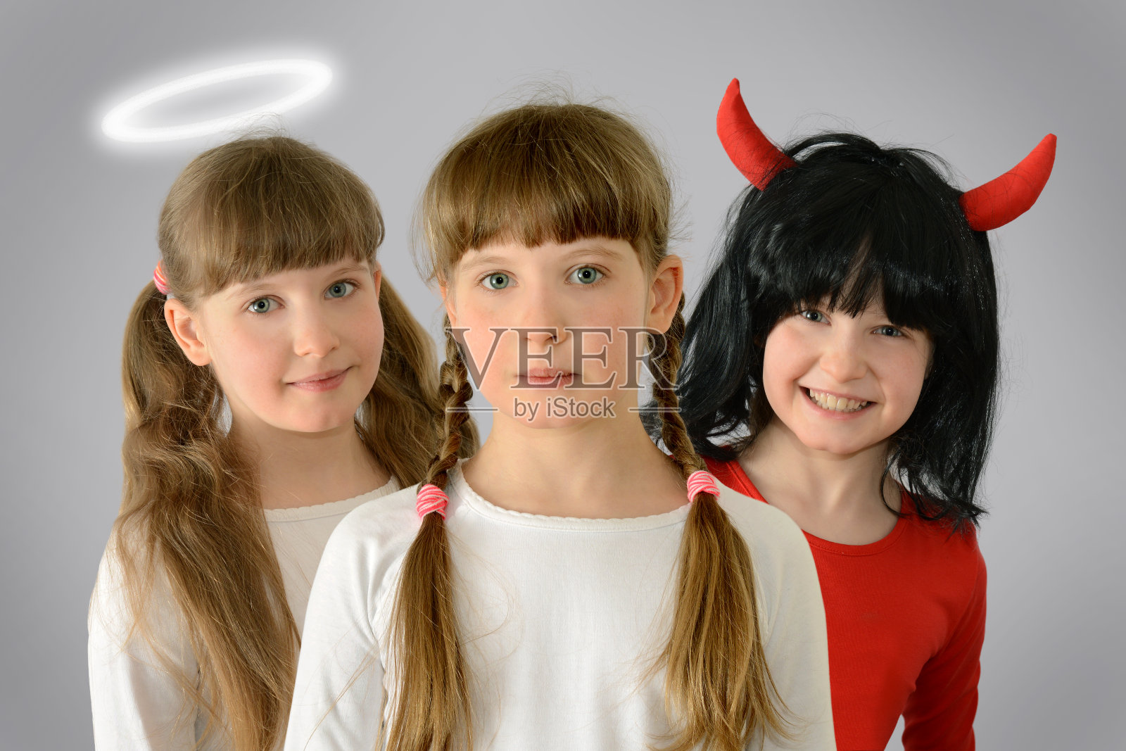 在孩子的肩膀后面是一个天使和一个魔鬼教善恶给概念摄影照片摄影图片