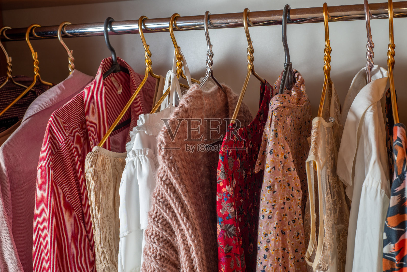 粉色的衣柜。衣柜里的衣架上挂着许多精致轻薄的夏装。
清理房间照片摄影图片