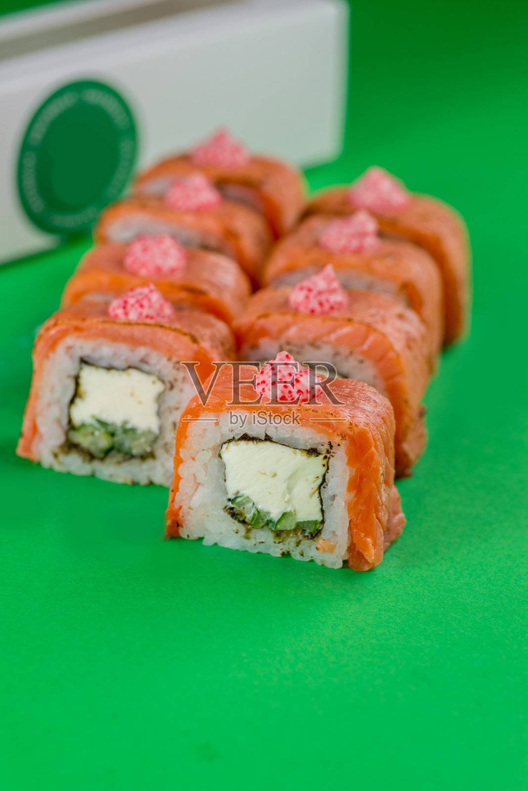 三文鱼和奶油芝士寿司，绿色背景。特写镜头照片摄影图片