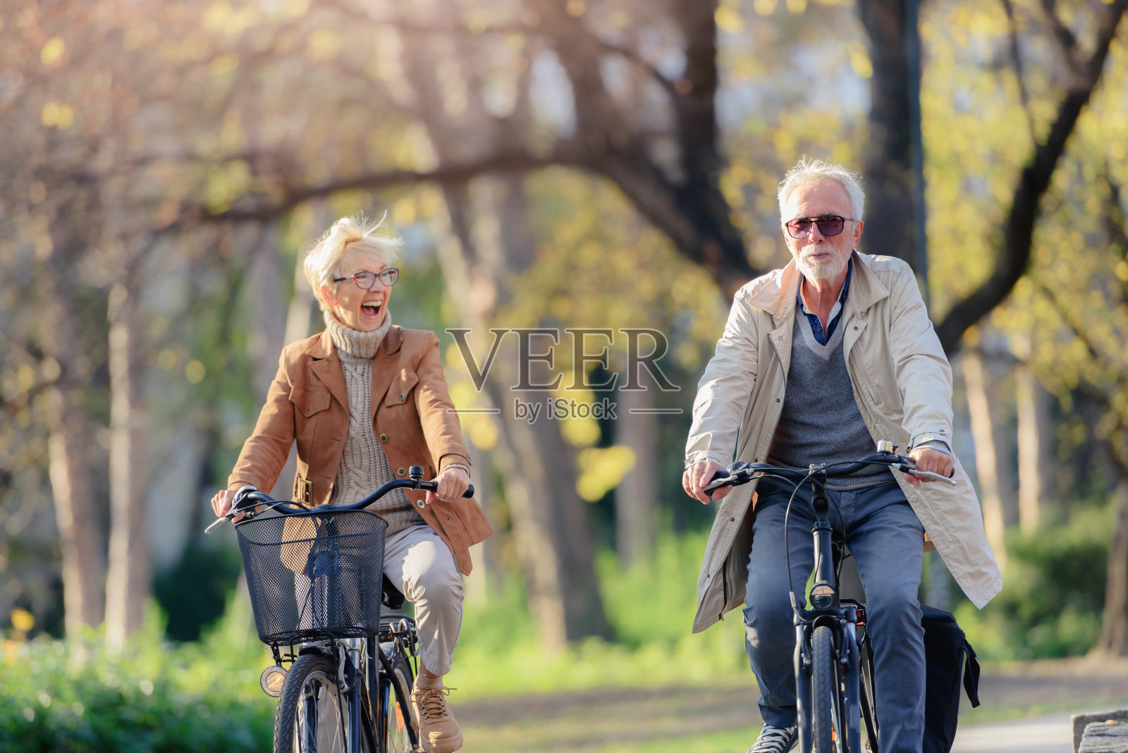 欢快活跃的老夫妇与自行车在公共公园一起玩照片摄影图片