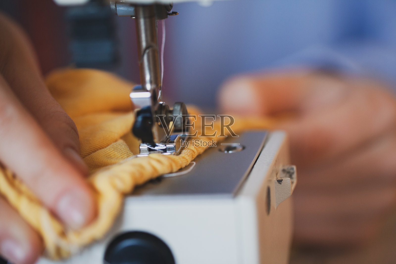 年轻的女裁缝在缝纫机上缝衣服照片摄影图片