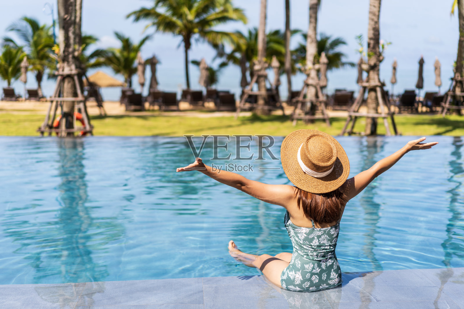 年轻女子旅行者放松和享受在一个热带度假池，而旅行的暑假，旅游概念照片摄影图片