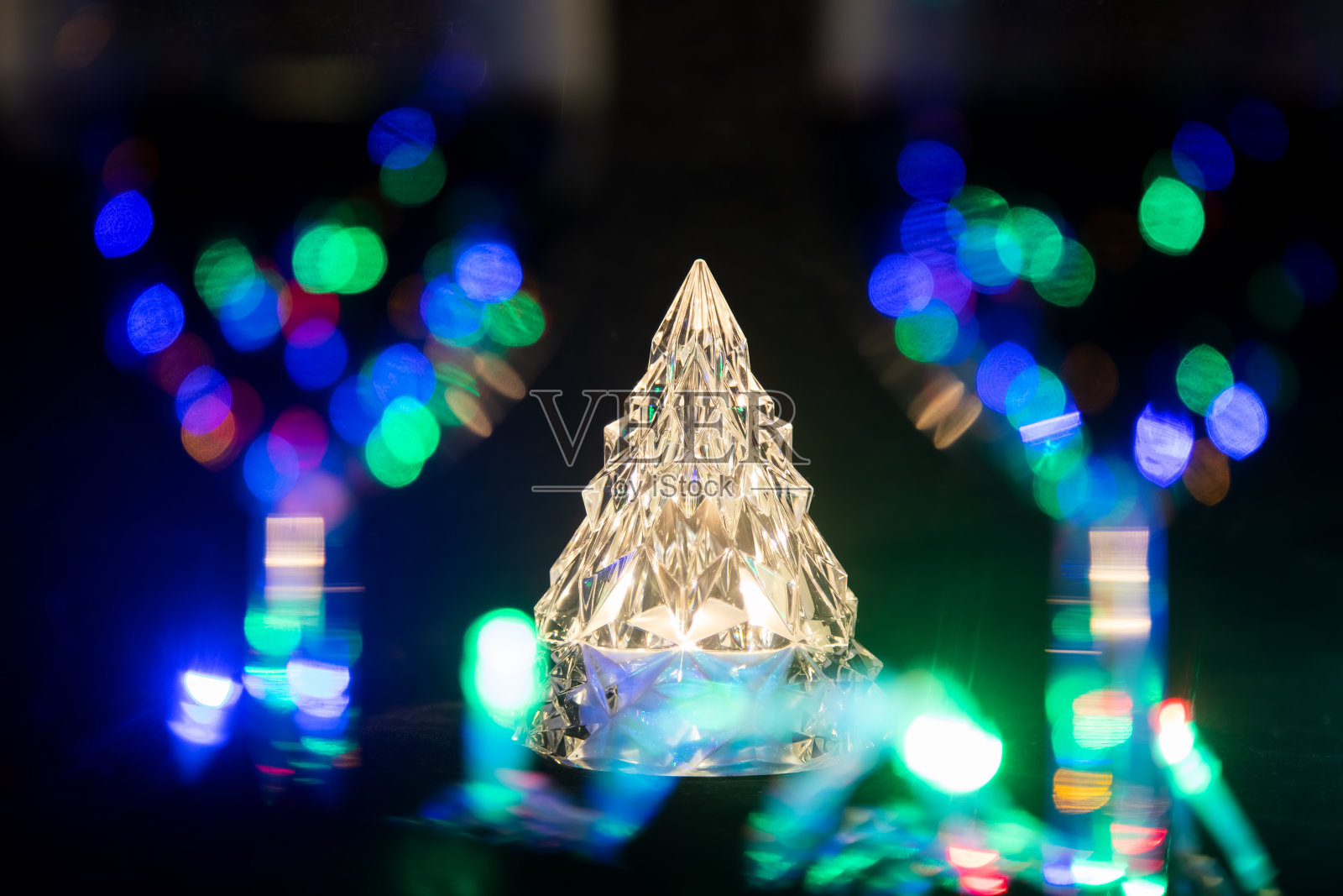 两个酒杯后面是一棵晶莹闪亮的圣诞树，周围是一个闪亮的花环。特写,软焦点照片摄影图片