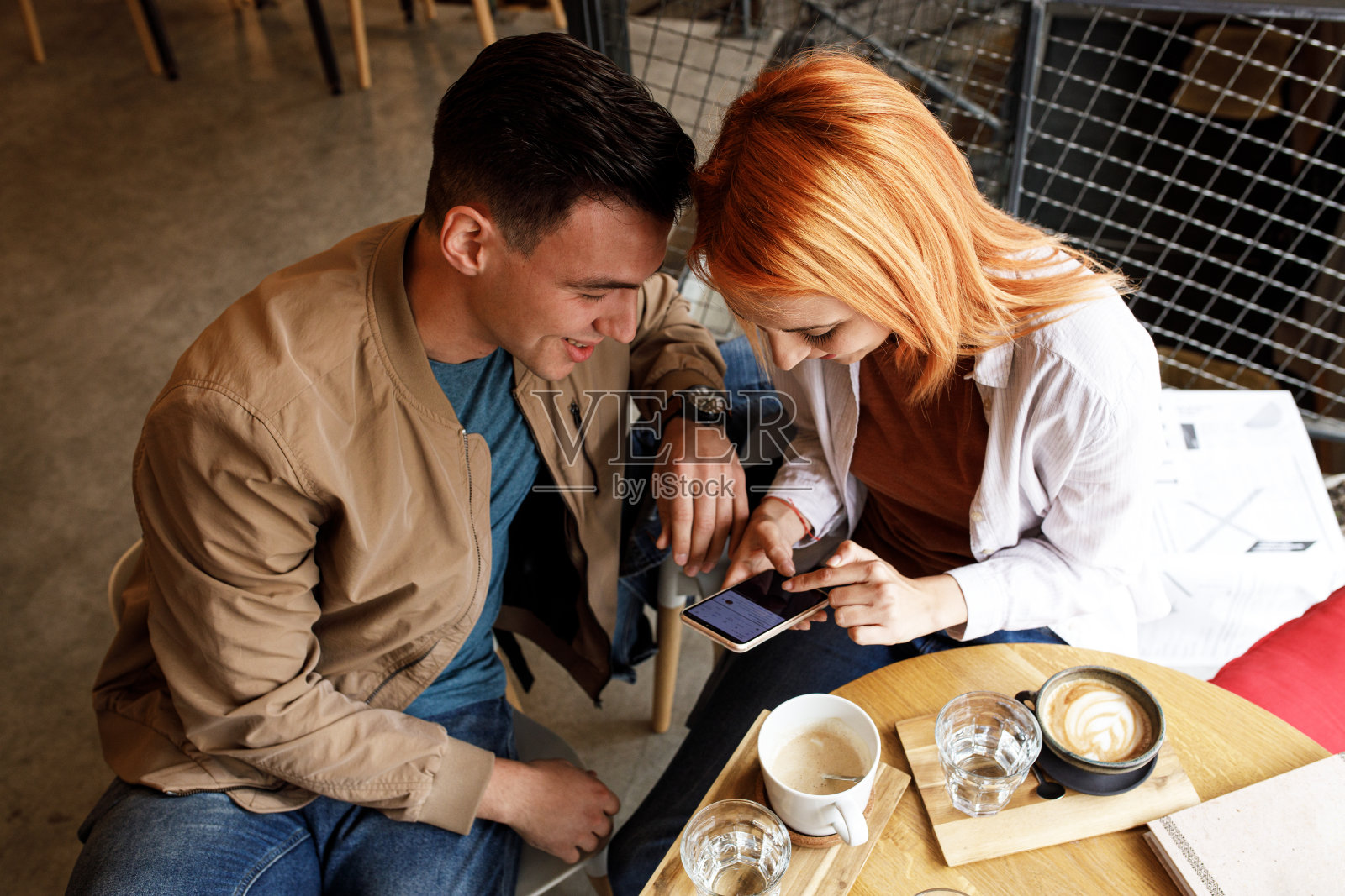 年轻夫妇在城市咖啡馆里聊天。照片摄影图片