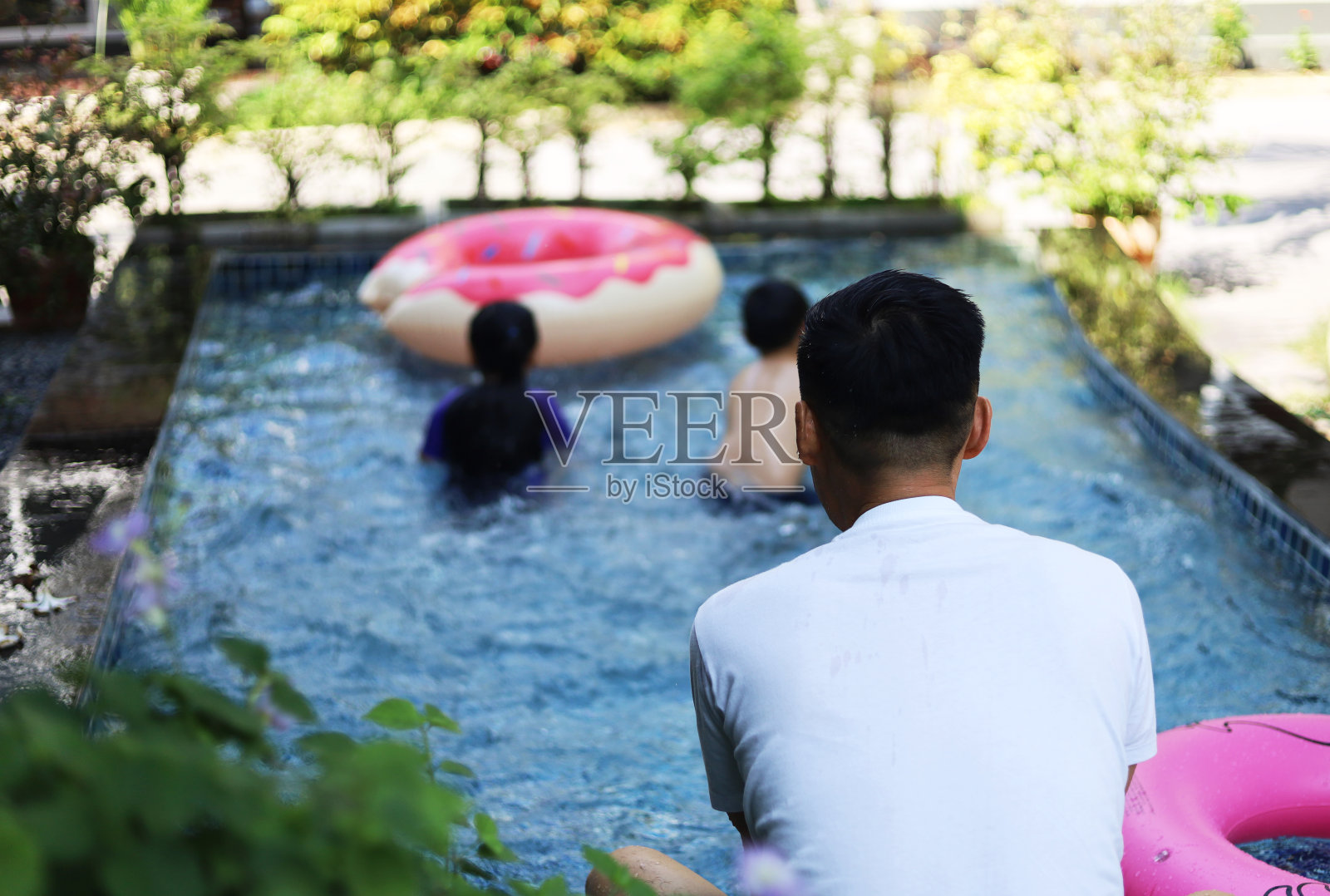 快乐亚洲的孩子们微笑放松，在酒店的游泳池里玩耍。照片摄影图片