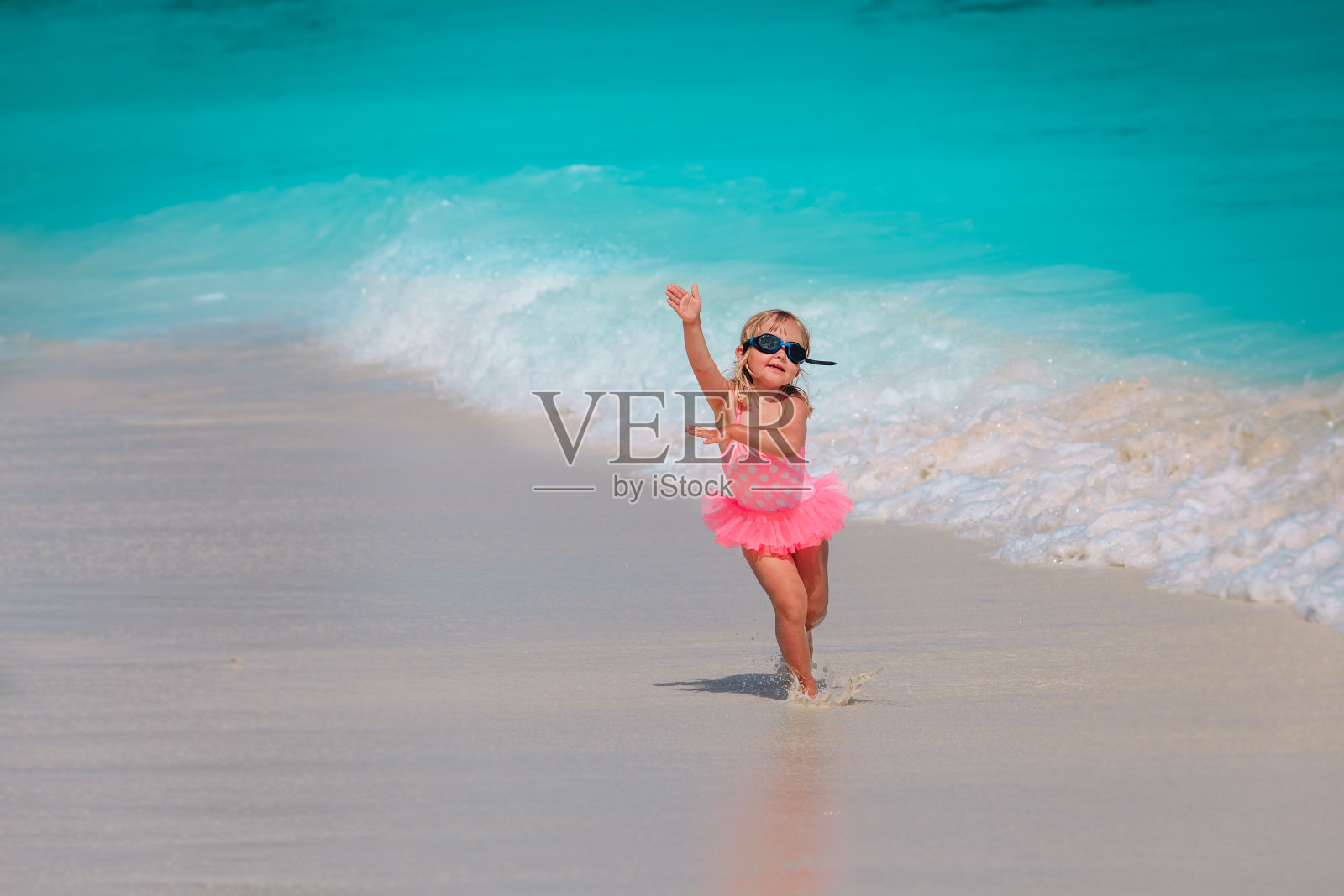 快乐的小女孩在沙滩上玩水，全家度假照片摄影图片