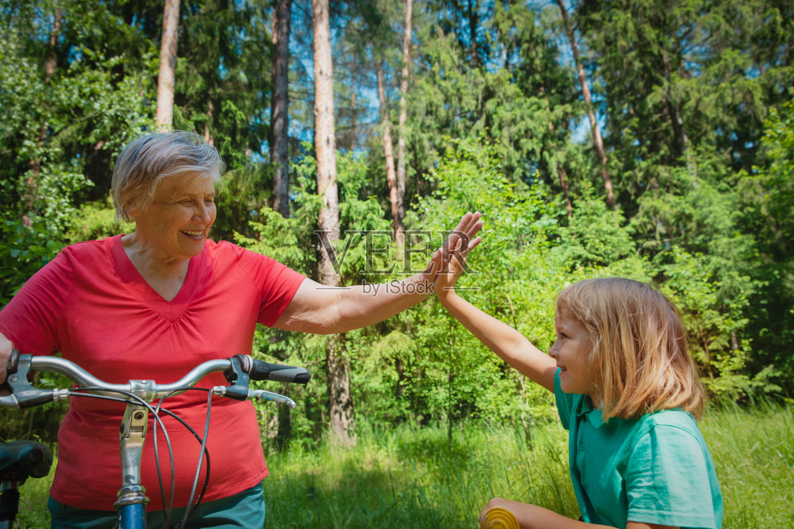 快乐的小女孩和奶奶在大自然中骑自行车照片摄影图片