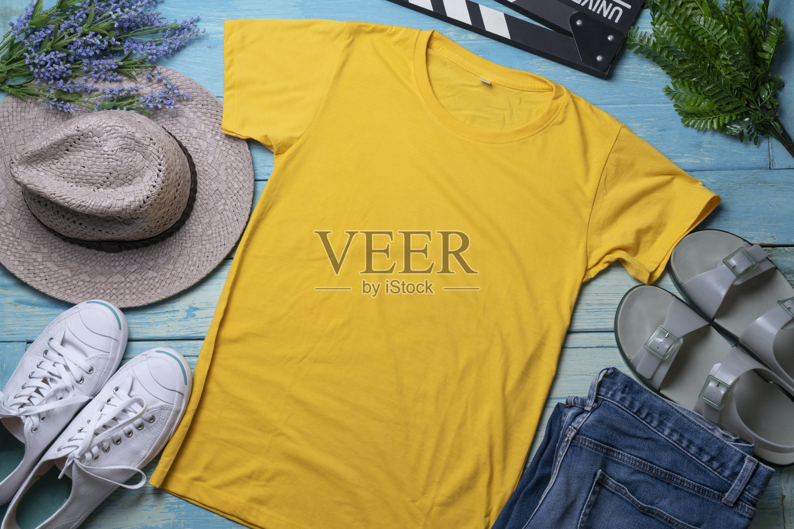一个黄色t恤空白衬衫模板与配件木制蓝色桌子背景，生活方式和旅游概念的模型照片摄影图片