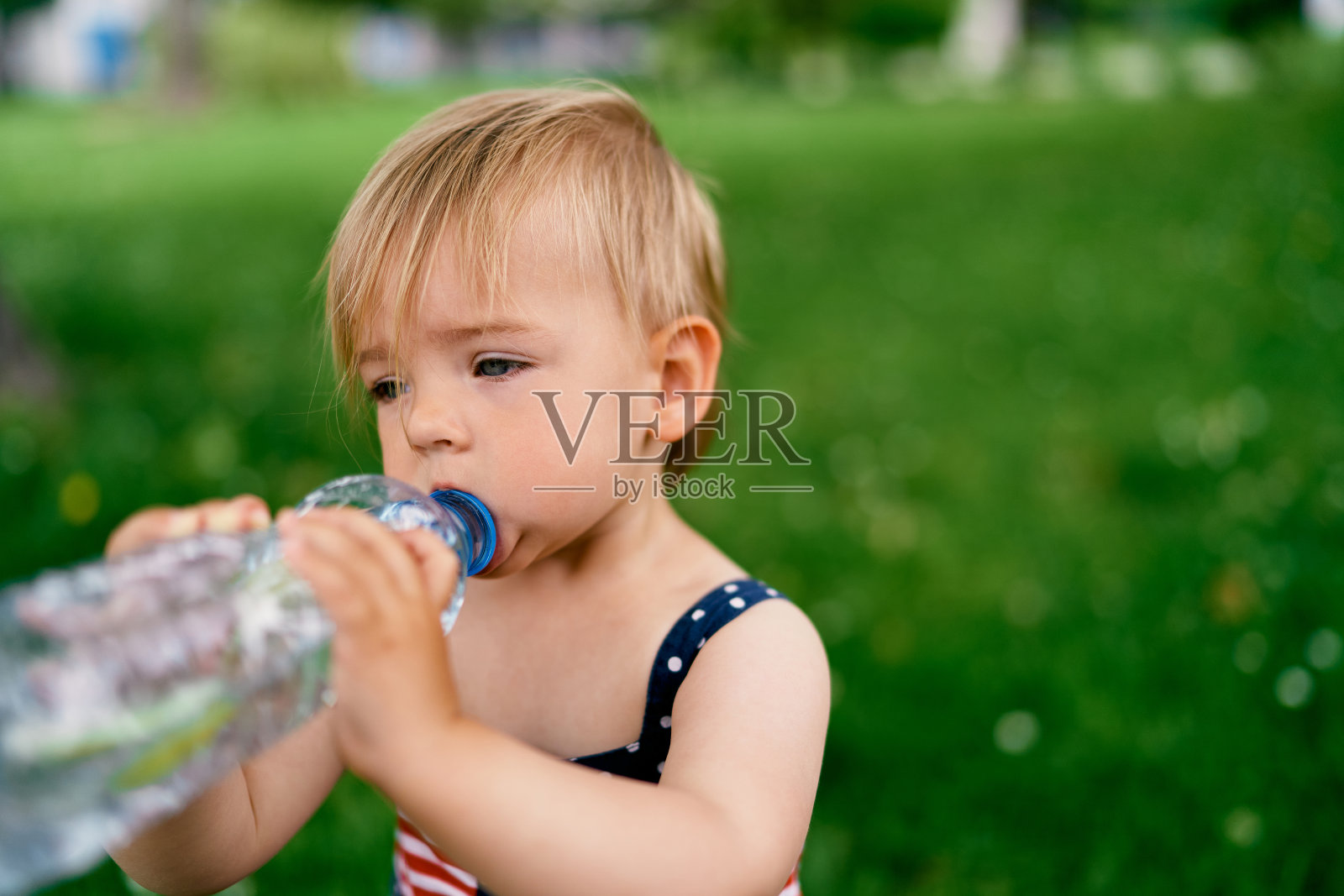 小女孩喝瓶子里的水照片摄影图片