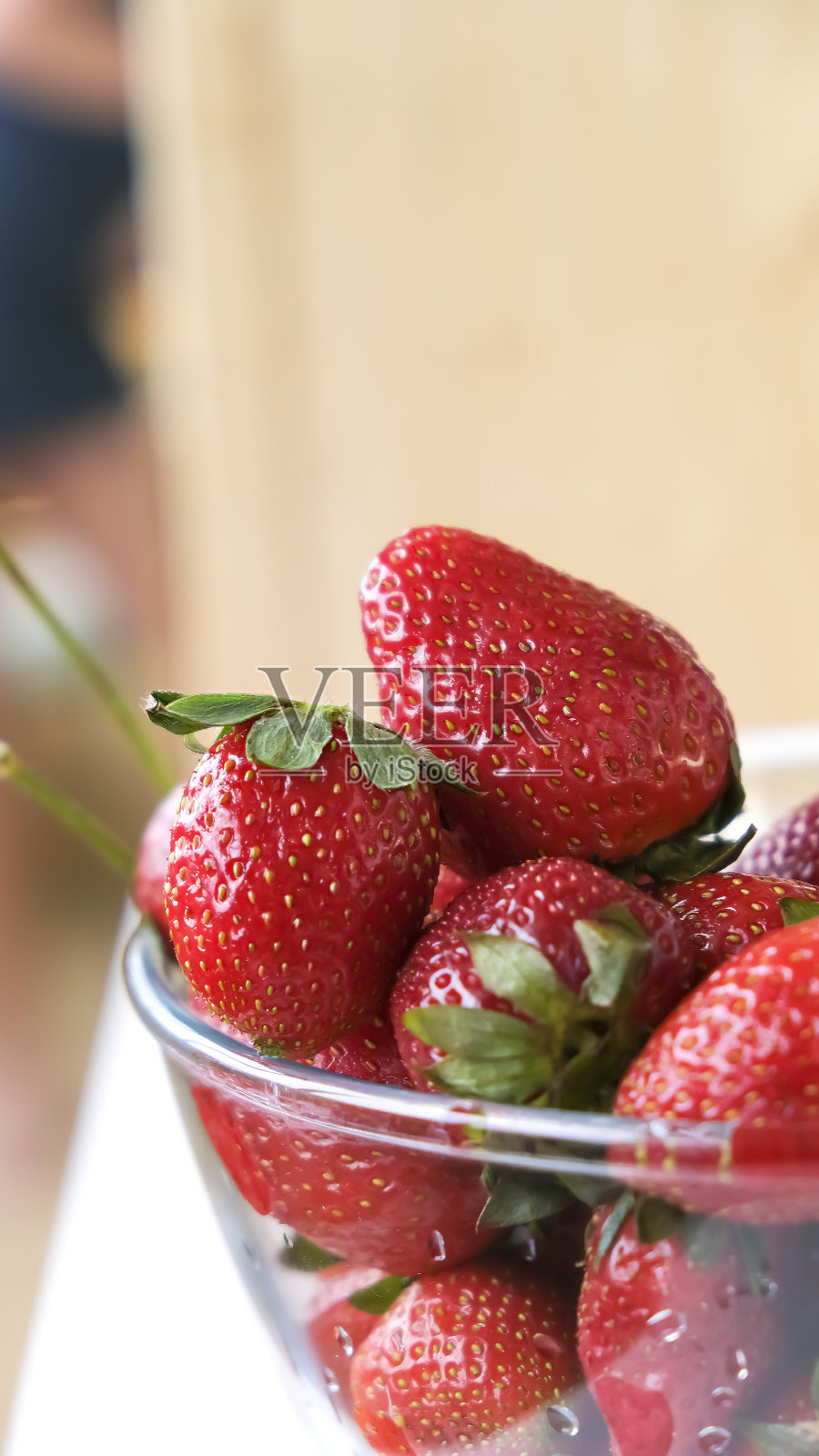 玻璃碗里装着成熟的红色有机草莓。夏天的水果和浆果。有选择性的重点。照片摄影图片