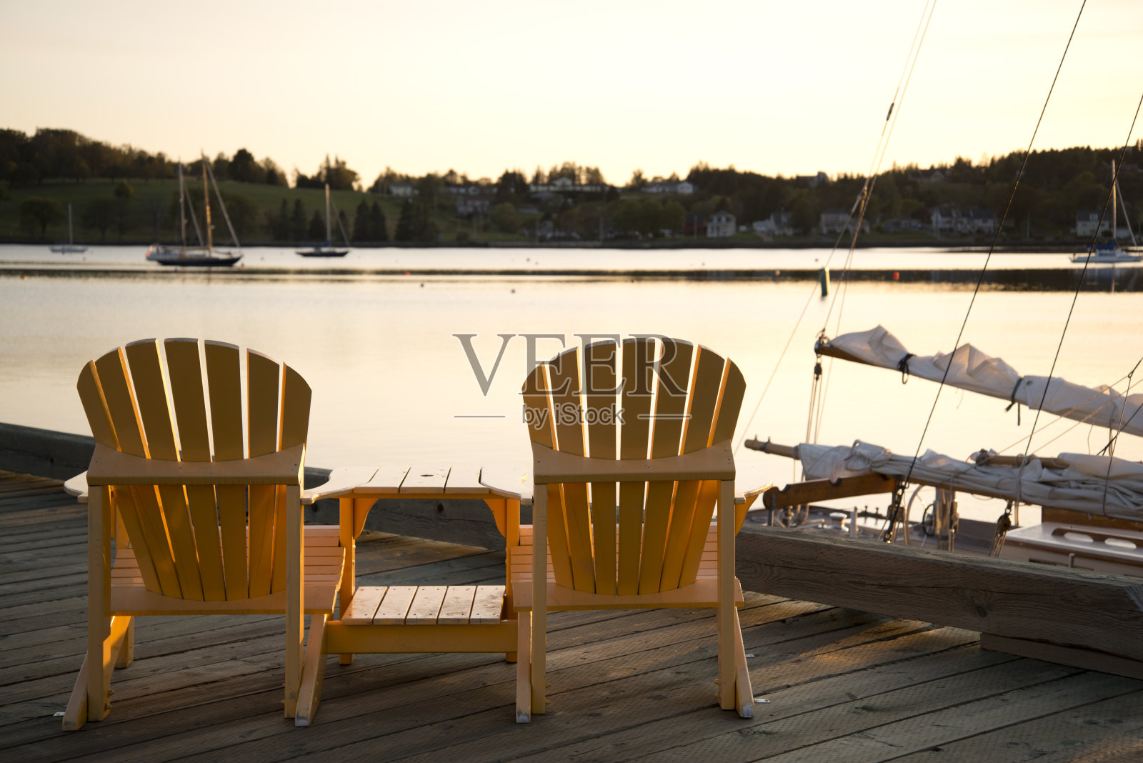 木制码头上的阿迪朗达克椅子。照片摄影图片