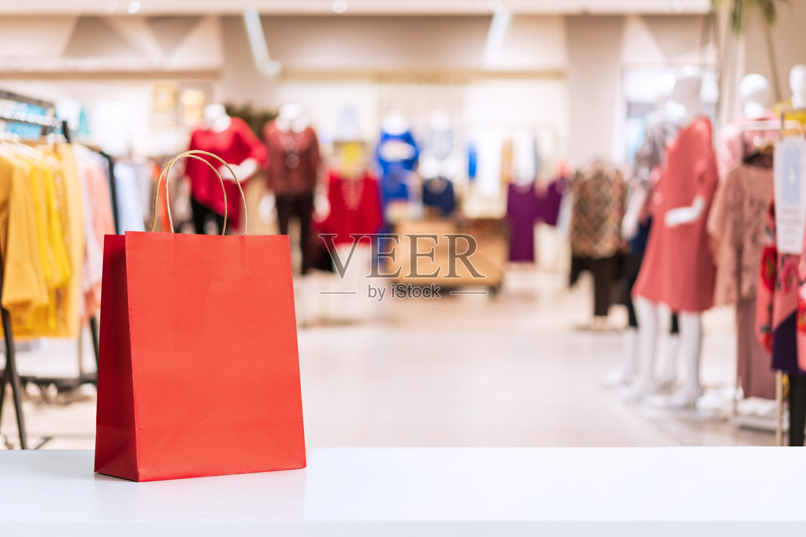 购物中心内部服装店的红色纸袋，背景抽象模糊照片摄影图片