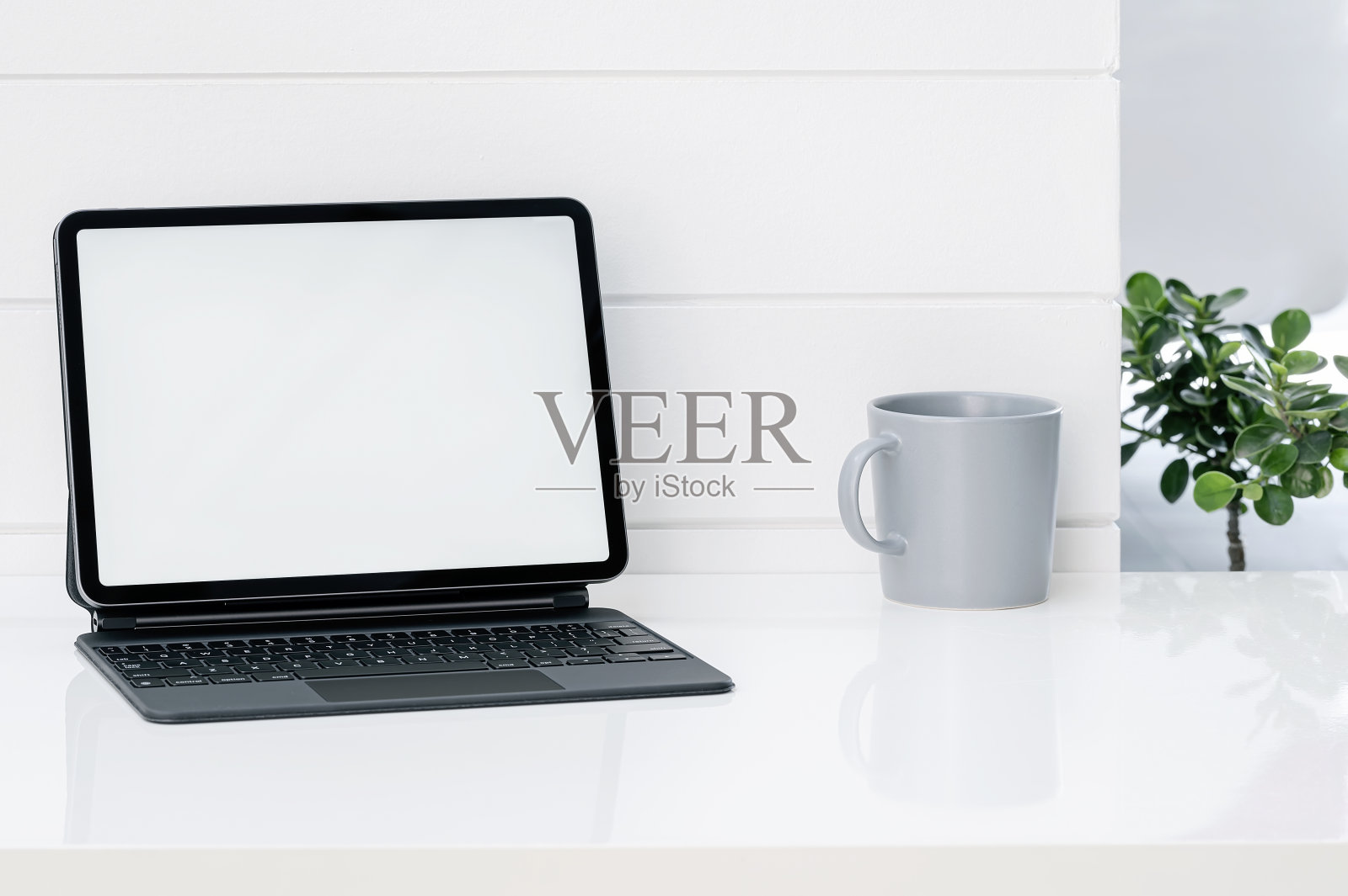 模型白色屏幕平板电脑与键盘和马克杯在白色桌上。照片摄影图片