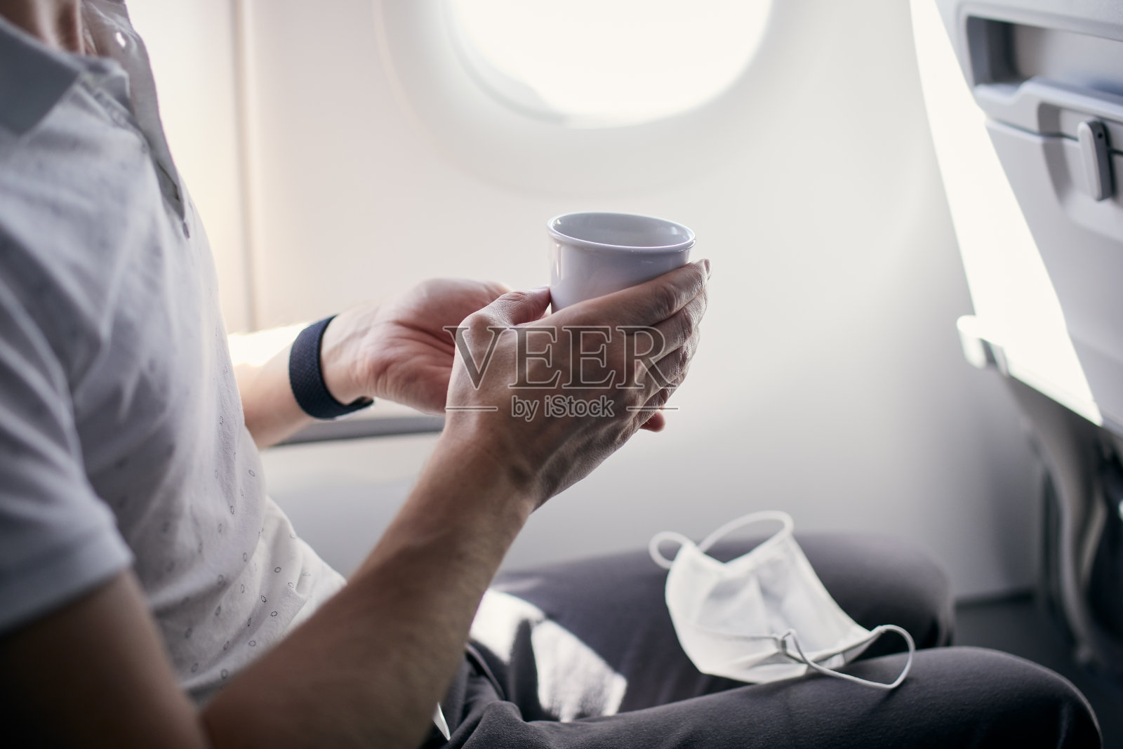 戴口罩的乘客在飞机上喝咖啡照片摄影图片
