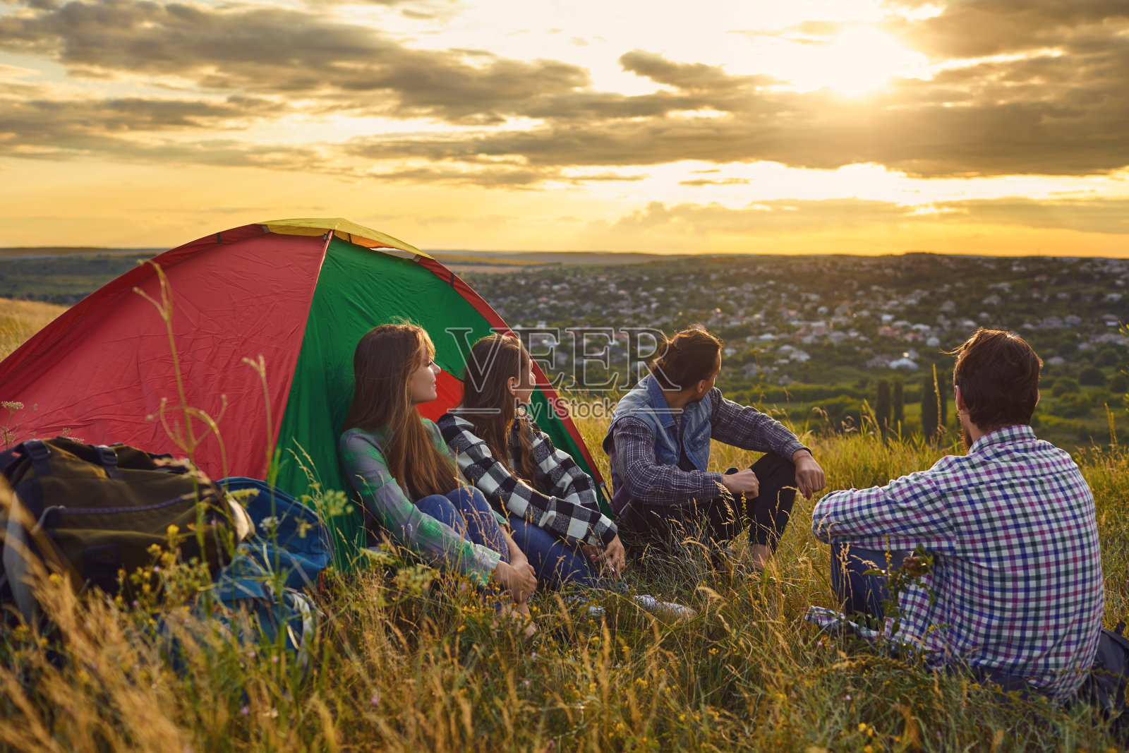 宿营帐篷宿营的人们，旅游者坐在大自然的日落。照片摄影图片