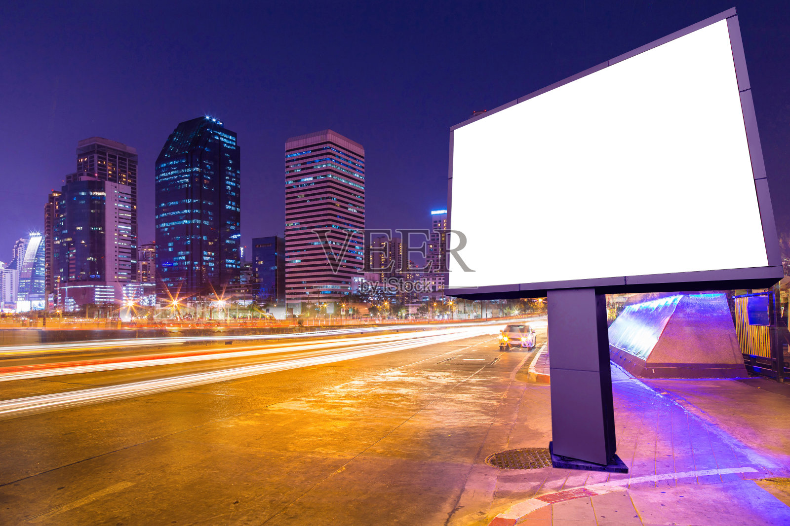 空白广告牌在灯光小径，街道和城市在夜晚-可以展示或蒙太奇产品或业务广告。照片摄影图片