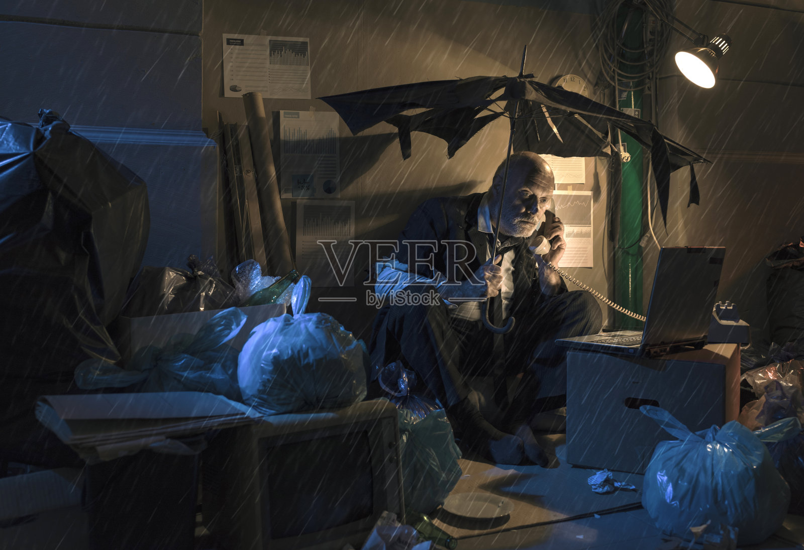 破产的无业商人坐在雨中的街道上照片摄影图片