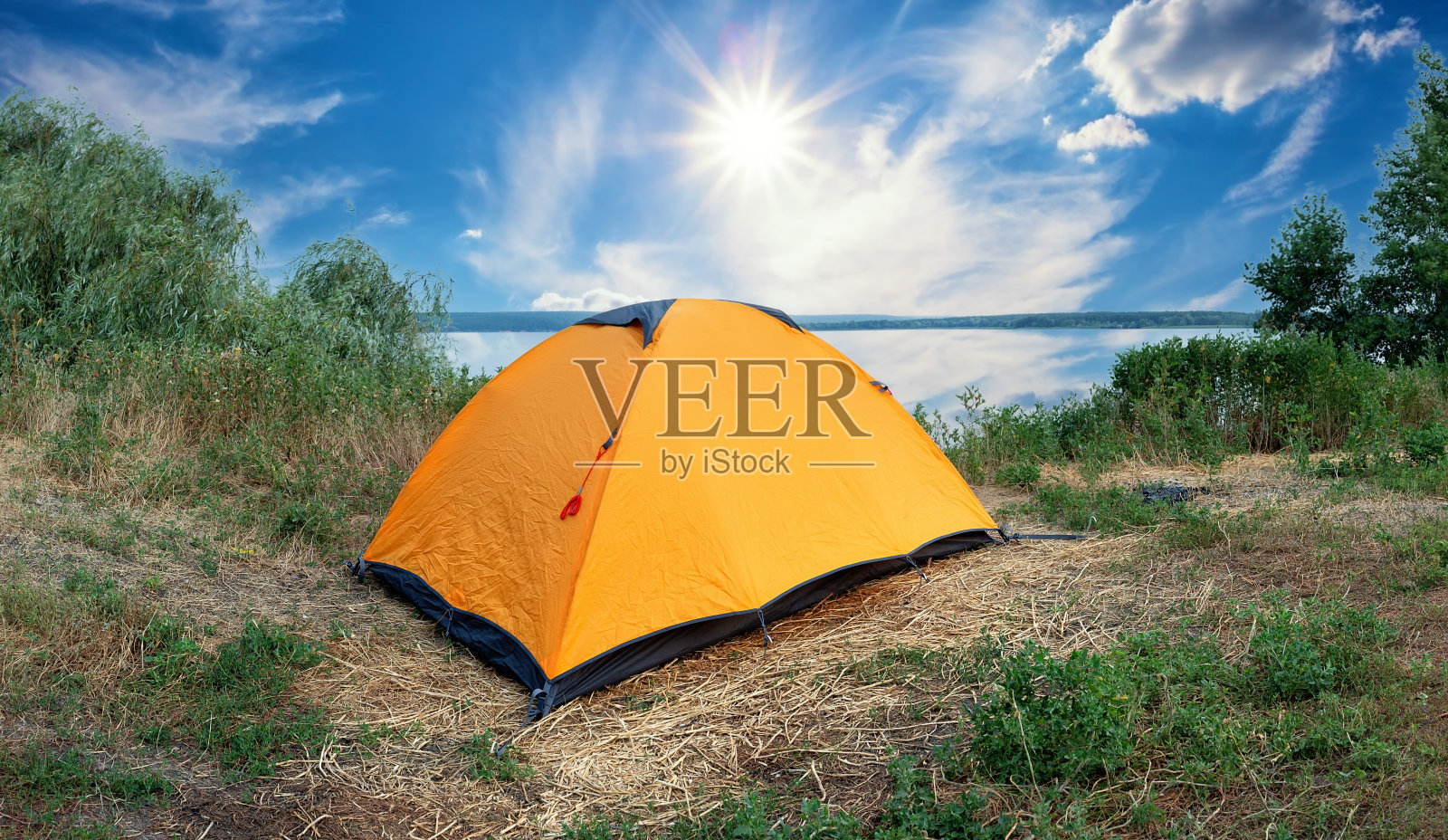 在明亮的阳光下湖边的橙色旅游帐篷照片摄影图片