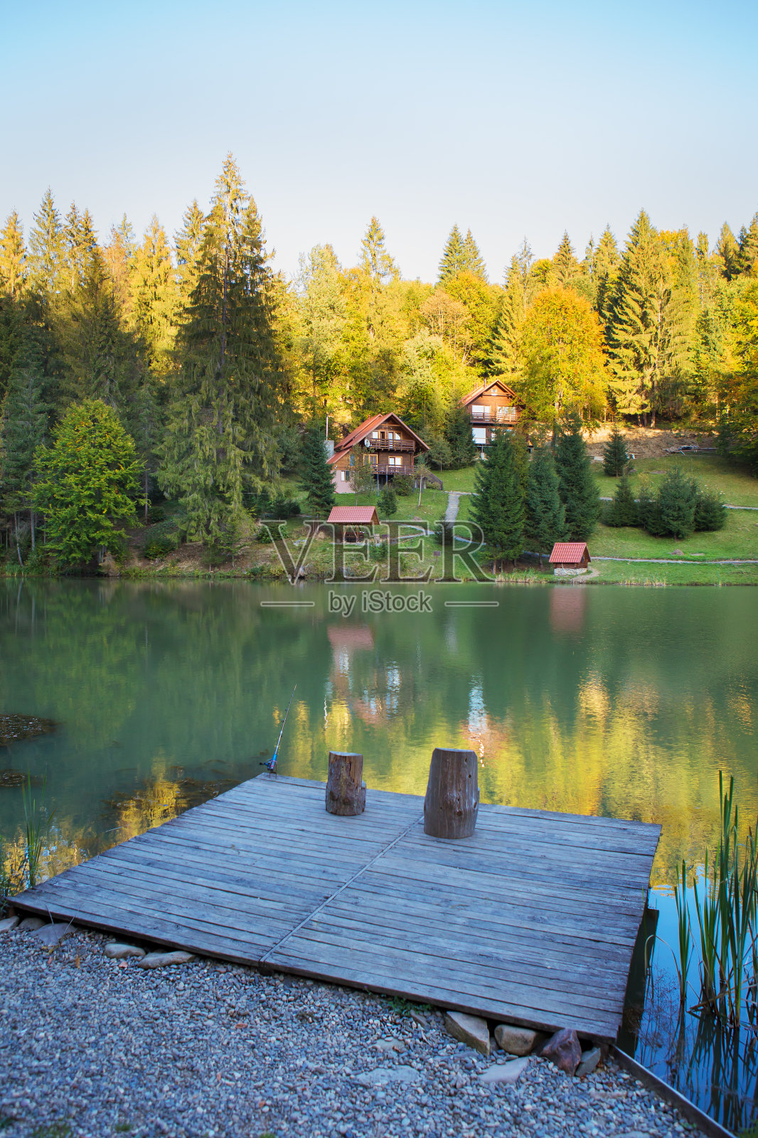 在美丽的秋天森林里的湖上钓鱼照片摄影图片