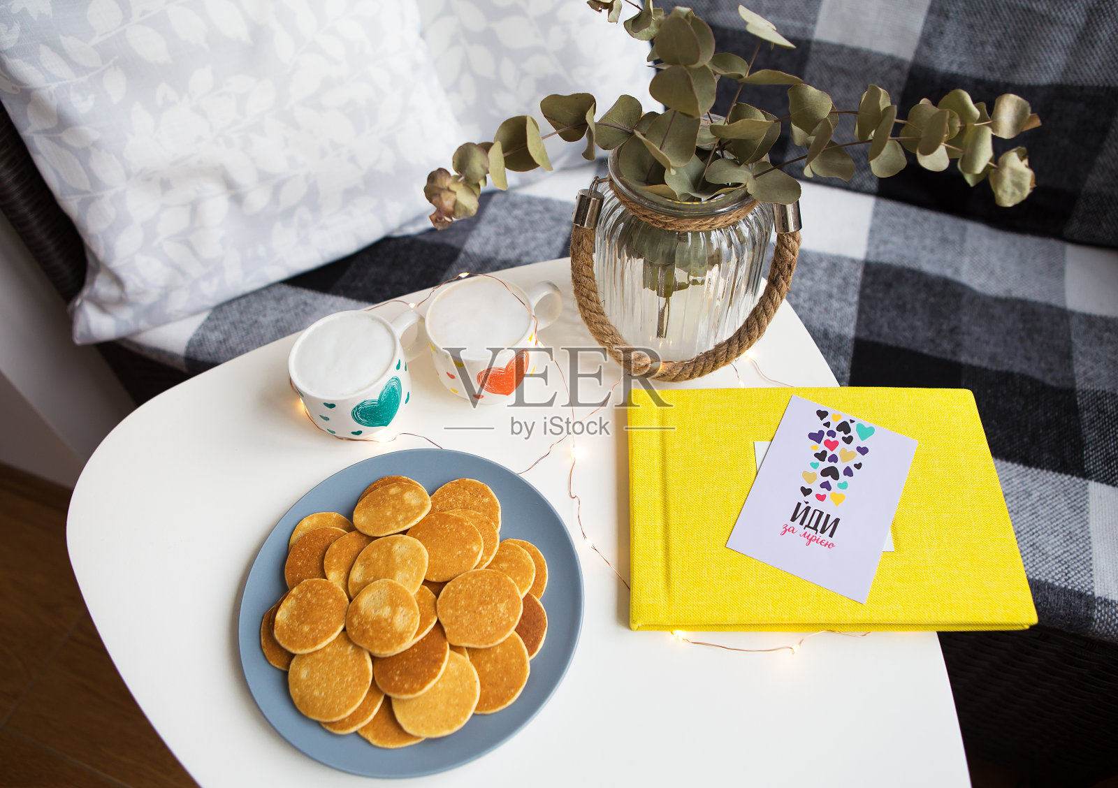 两杯咖啡和美味的煎饼摆在桌上，黄色的相册照片摄影图片