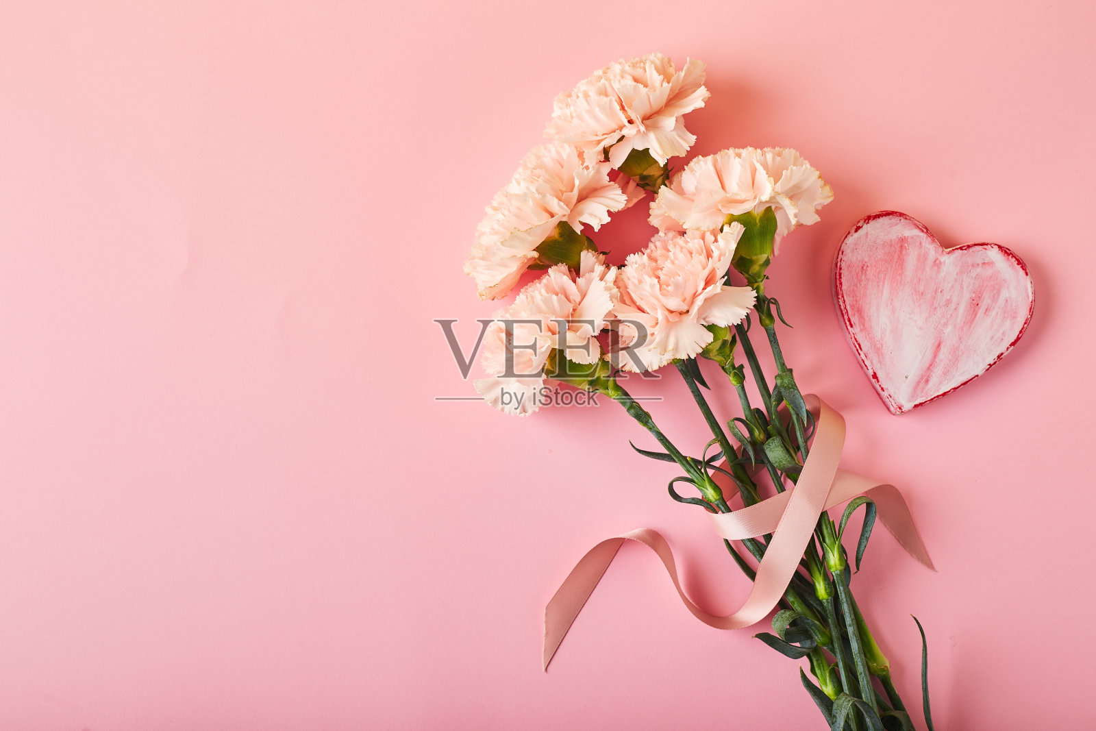 一束粉红色的康乃馨。设计理念假日问候与康乃馨花束粉红色的桌子背景照片摄影图片