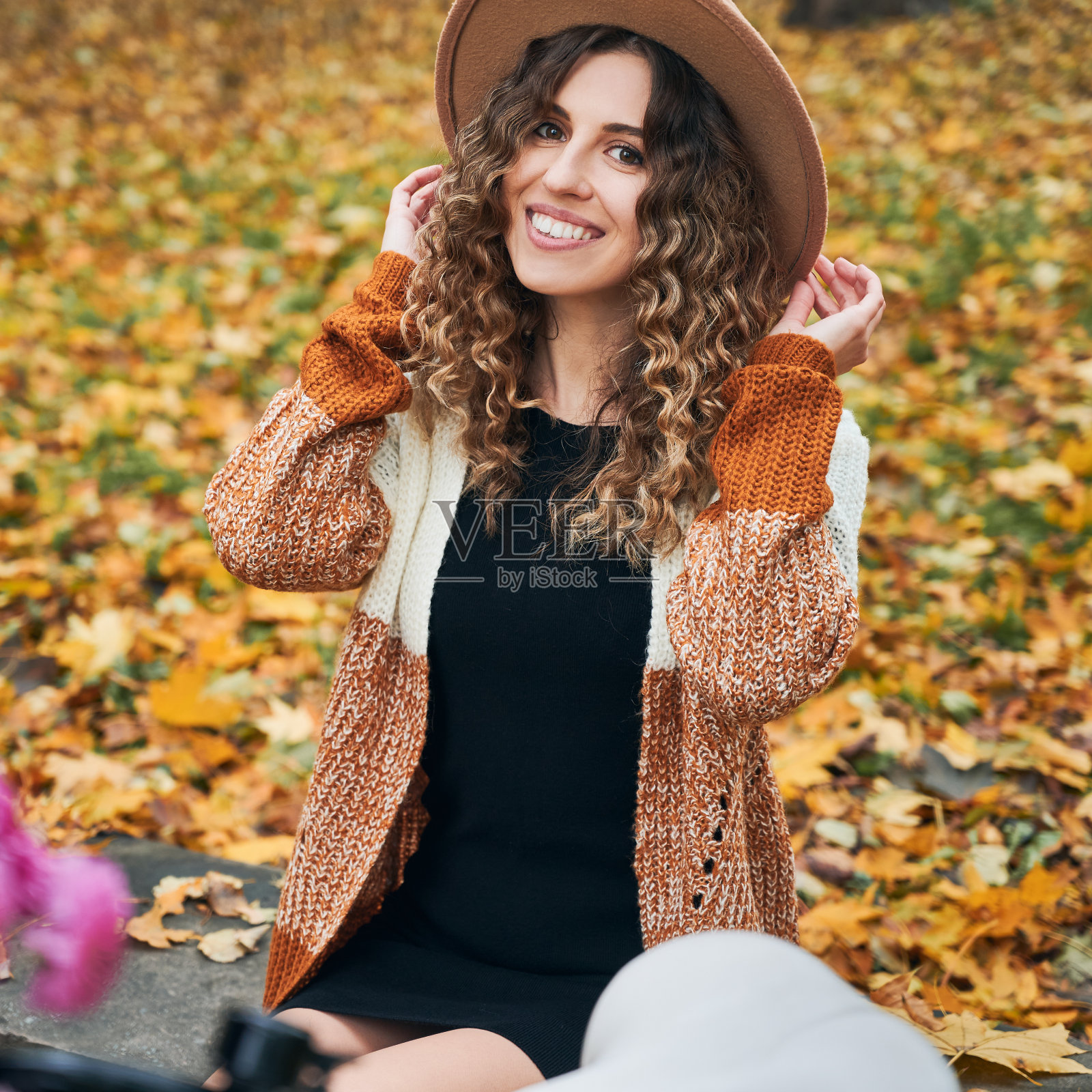 快乐的年轻女子坐在秋天的街道上。照片摄影图片
