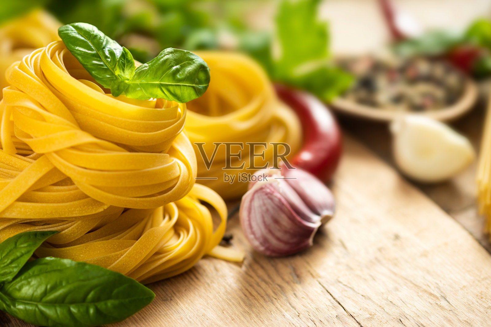 木桌上放有罗勒叶、胡椒、大蒜和欧芹的意大利面条和意大利面照片摄影图片