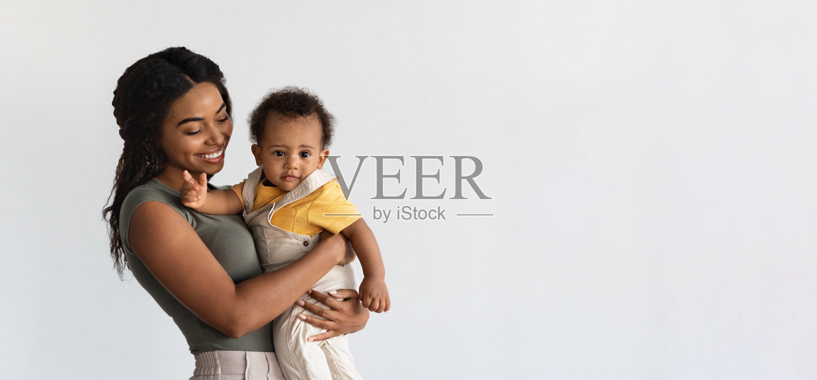 母亲的概念。微笑的年轻黑人母亲抱着可爱的婴儿照片摄影图片