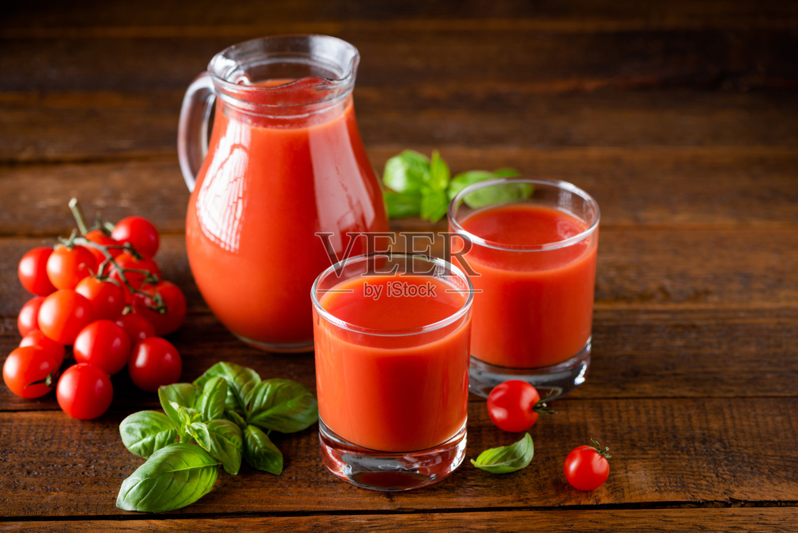 番茄汁装在玻璃杯里，木桌为背景照片摄影图片