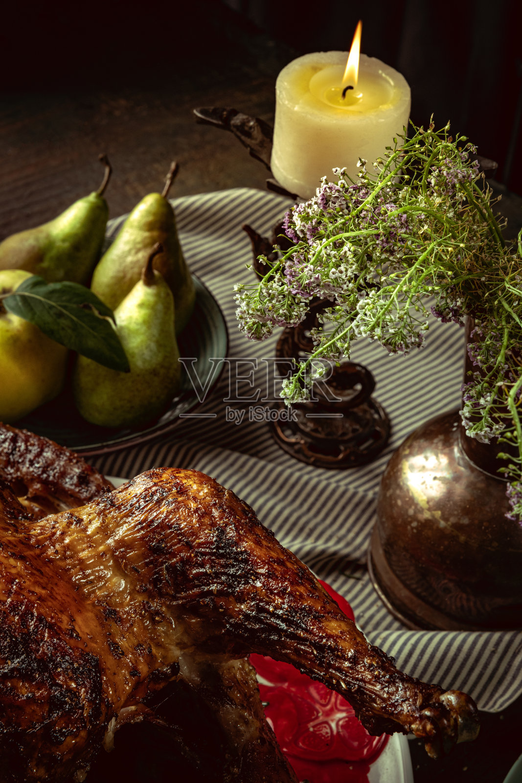 装饰的餐桌为秋季假日晚餐。烤火鸡，几杯葡萄酒和小南瓜照片摄影图片