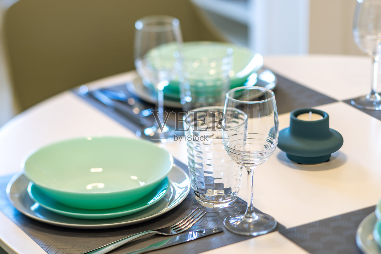 在桌子上摆上干净的蓝色盘子和空杯子。照片摄影图片