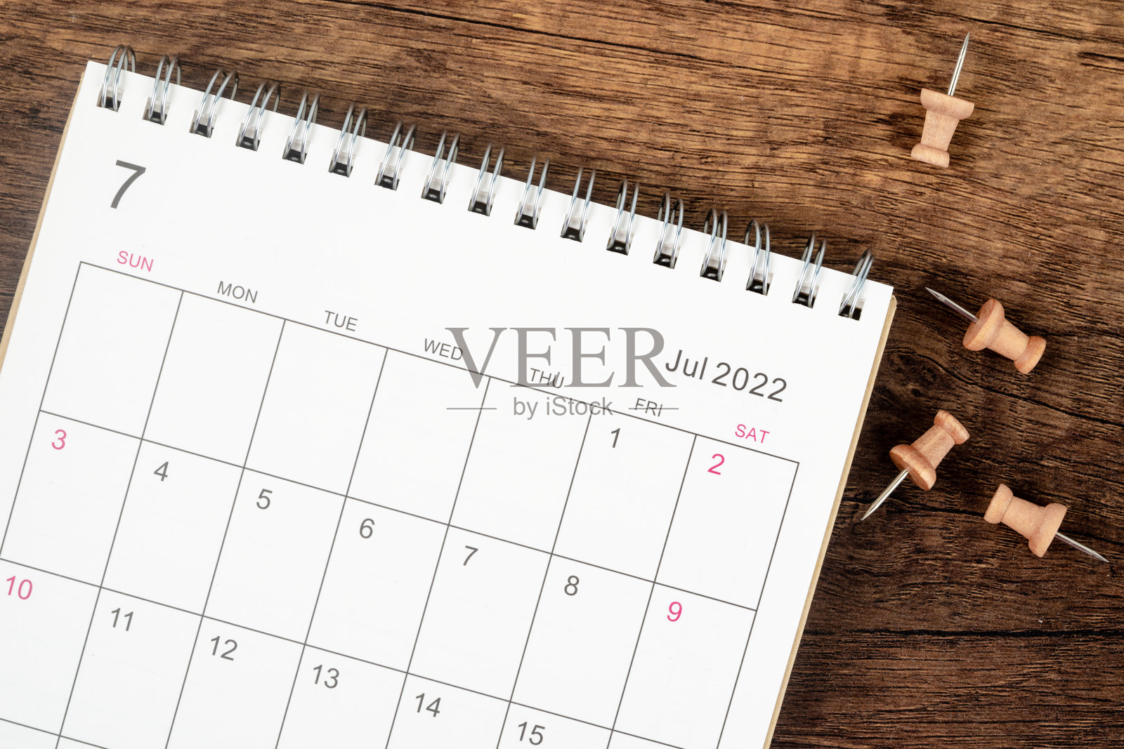 俯视图日历桌2022年7月月，概念规划和期限与木桌背景上的推杆。照片摄影图片