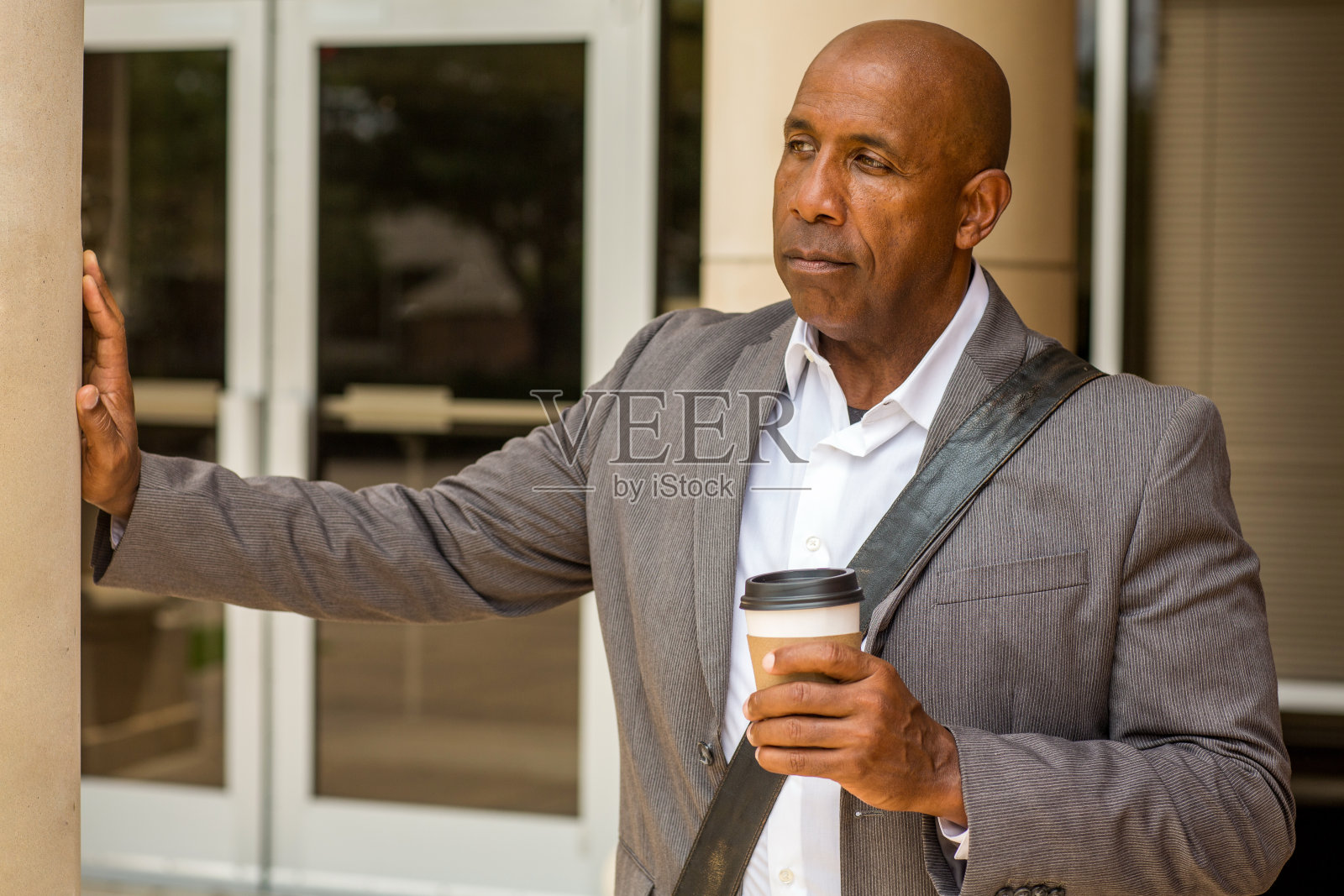 一个成熟的非裔美国人站在他的办公室外面，没有微笑。照片摄影图片