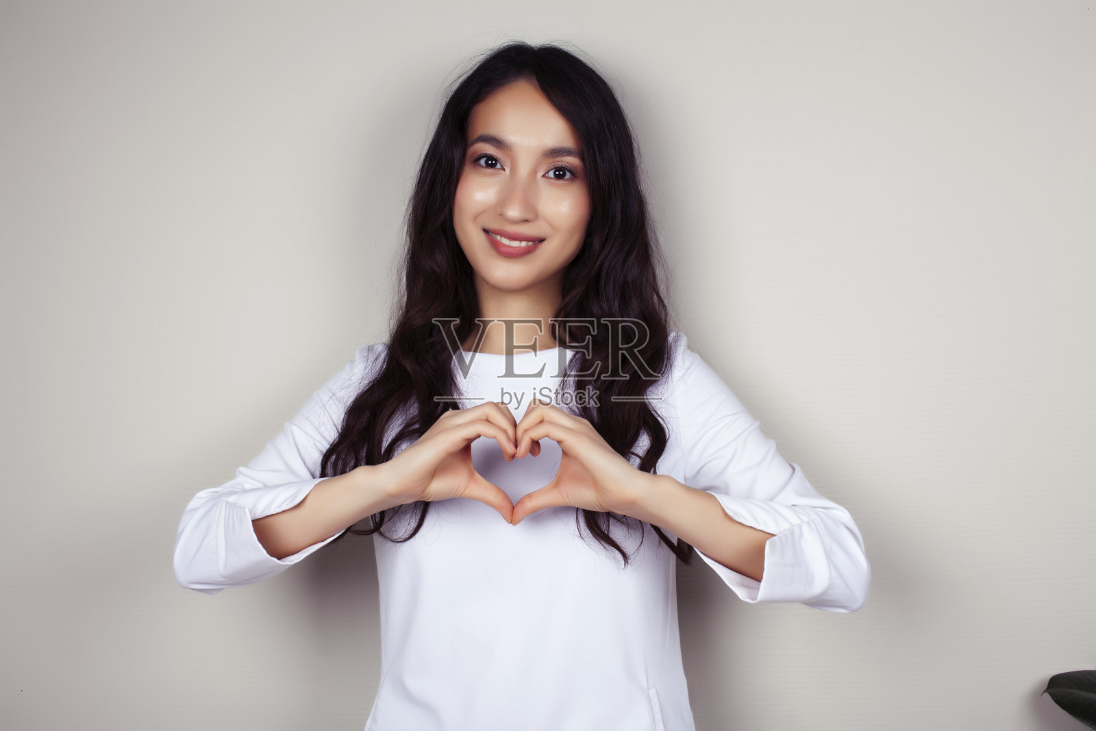 年轻的亚洲女医生在白色制服的手势积极的灰色背景，生活方式保健人的概念照片摄影图片
