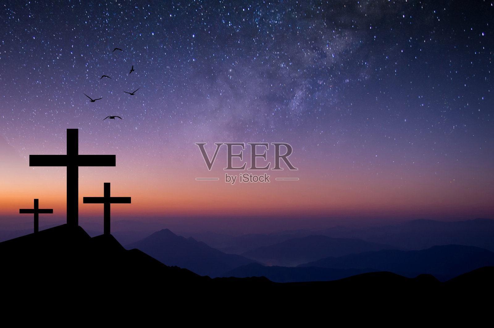 耶稣在黑夜里被钉死在十字架上，复活在星星和银河中。照片摄影图片