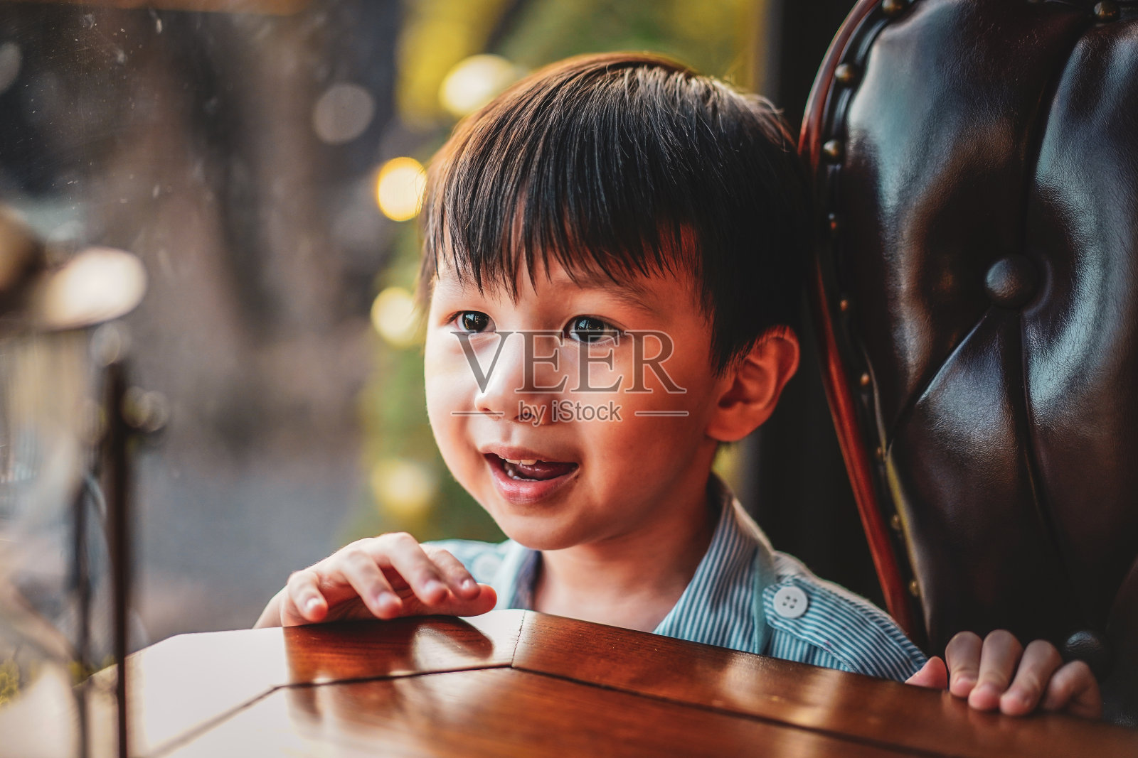 近景拍摄有趣可爱的微笑的小男孩在复古风格的房子。照片摄影图片