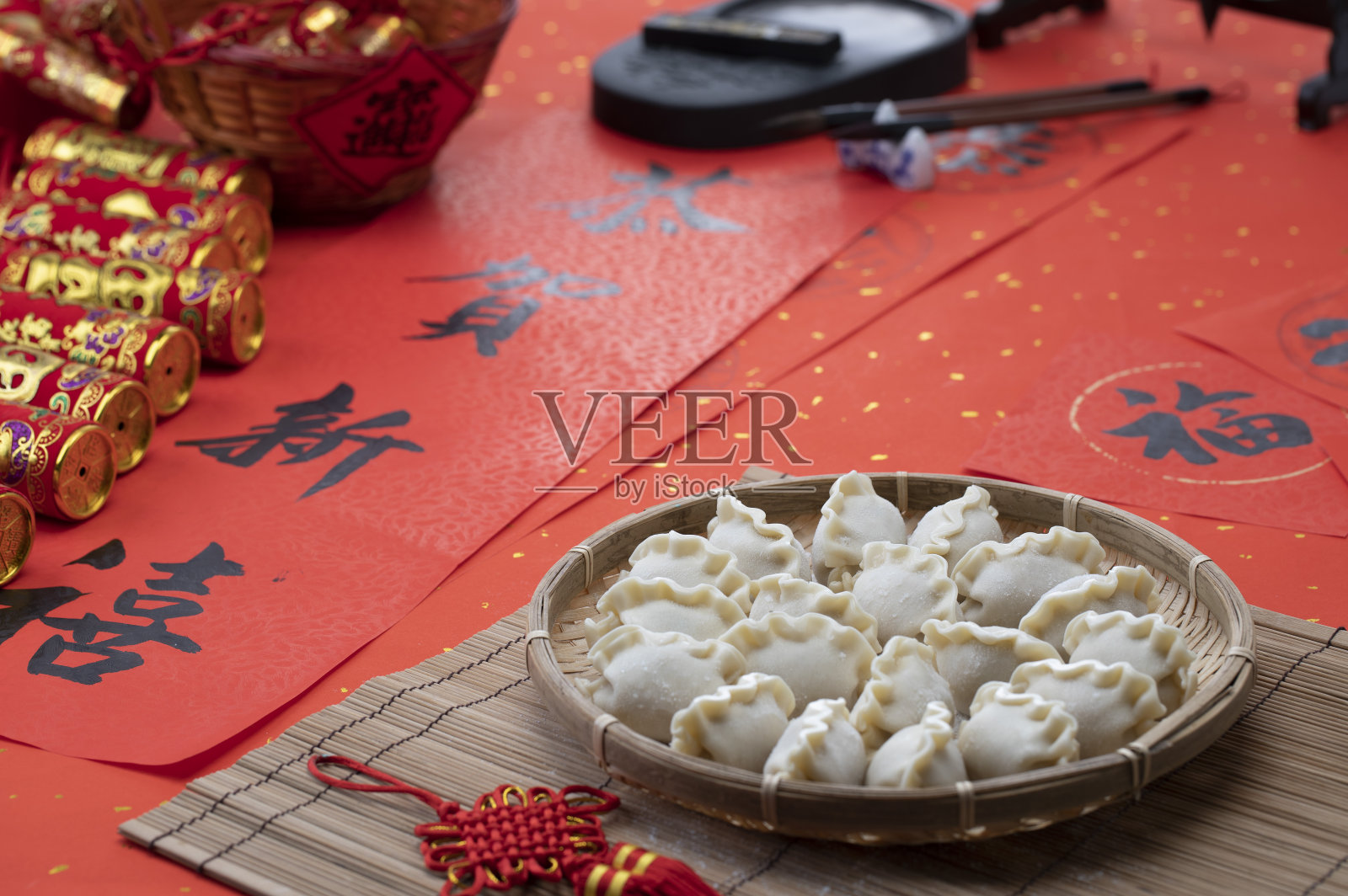 中国新年合家团圆包水饺元宝放在恭贺新喜的春联上照片摄影图片