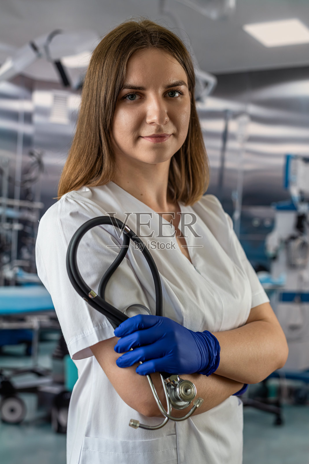 医院手术室白衣女护士佩戴听诊器的画像。照片摄影图片