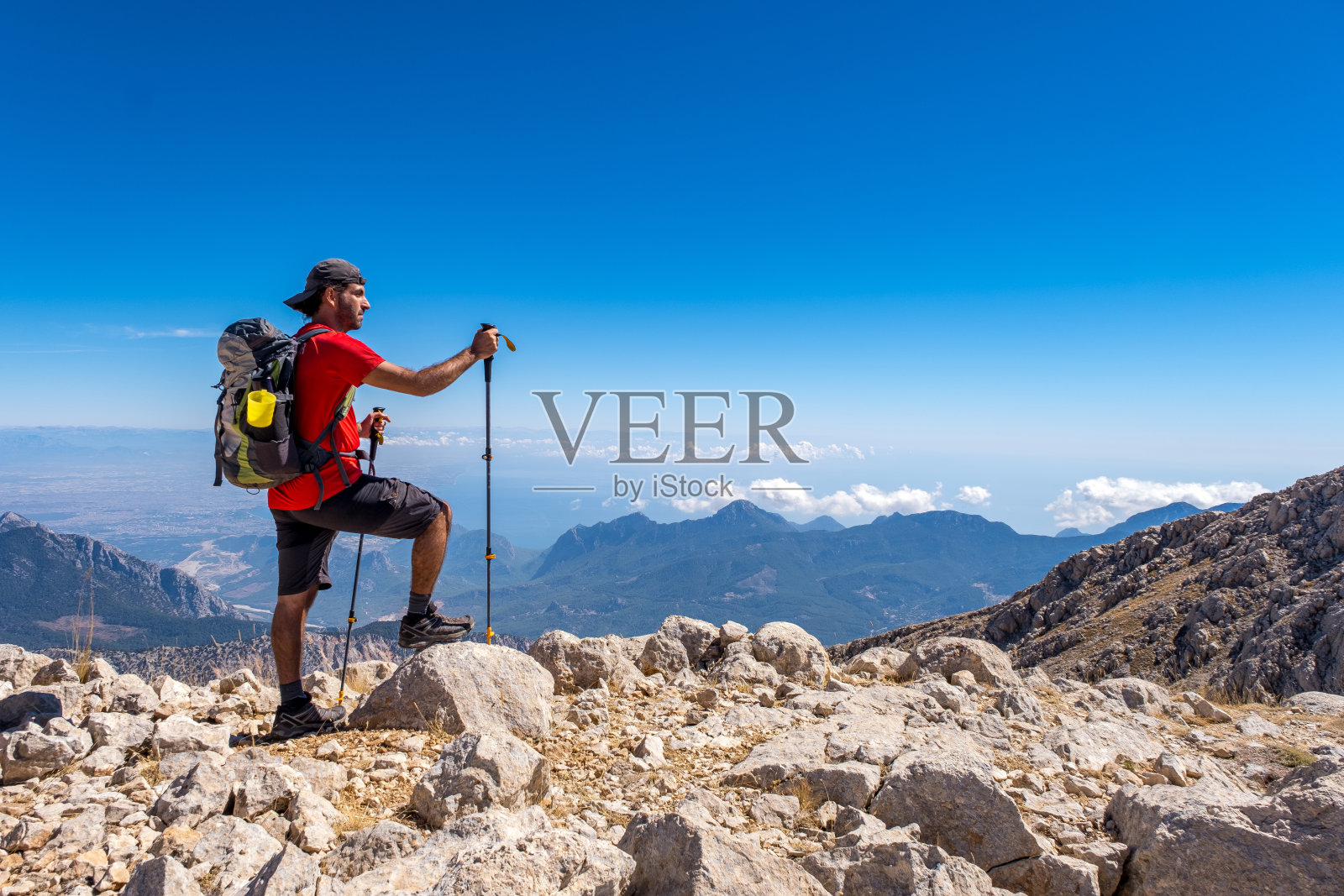 一个背着背包的男人在秋天的一天在森林里徒步旅行的背影图片-商业图片-正版原创图片下载购买-VEER图片库