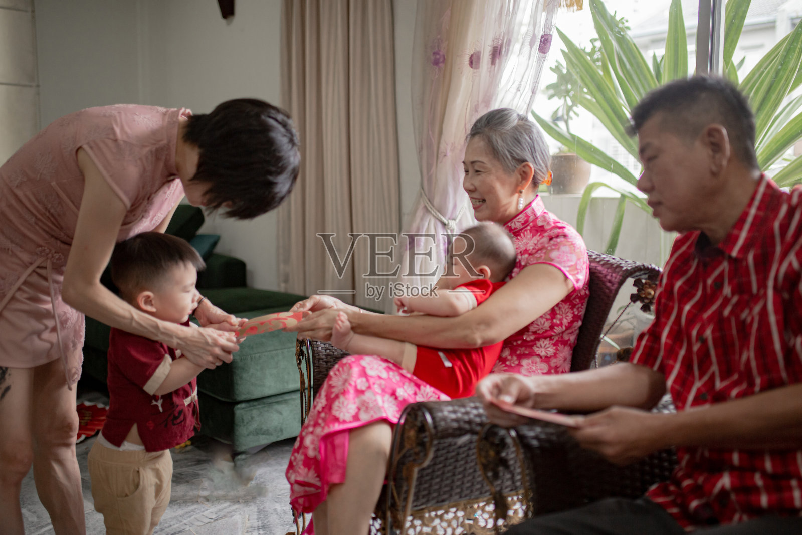 亚洲的祖父母在中国新年快乐地给孙辈发红包照片摄影图片