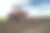 农业的特写，红色的拖拉机在蓝天上耕种田地素材图片